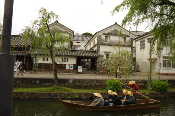 倉敷川を行く川船と白壁の民芸館